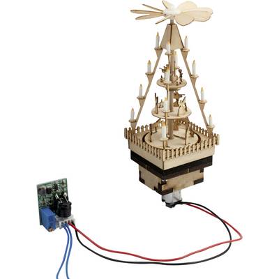 Piccolo modello di giostra in legno motorizzato con luci simili a candele, mostrato con una scheda circuitale collegata e fili.