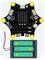 Scheda controller Micro:bit collegata a un pacco batterie a tre stilo AA tramite fili rossi e neri.