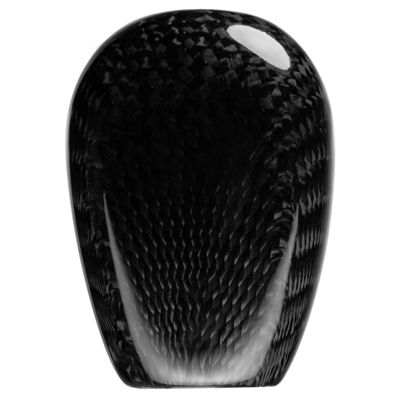 Primo piano di un guscio o involucro in fibra di carbonio nero lucido, forma rettangolare arrotondata con riflessi brillanti su sfondo bianco.