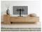 TV schermo piatto su un mobile in legno basso, con un vaso di rami sulla sinistra e un cuscino rotondo sulla destra in un minimalista soggiorno.