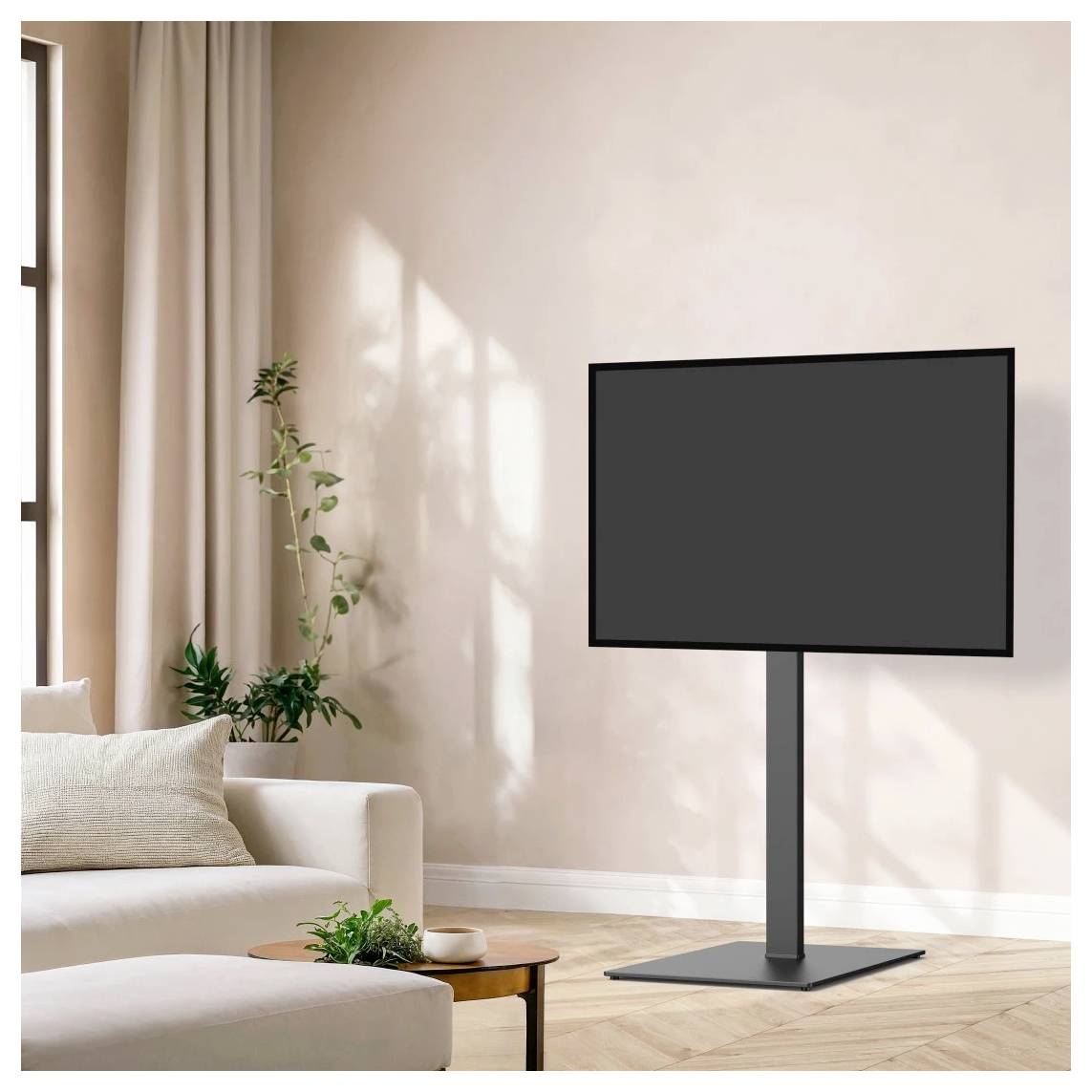 TV a schermo piatto su un supporto in un luminoso soggiorno minimalista accanto a un divano, un tavolino da caffè e piante in vaso.