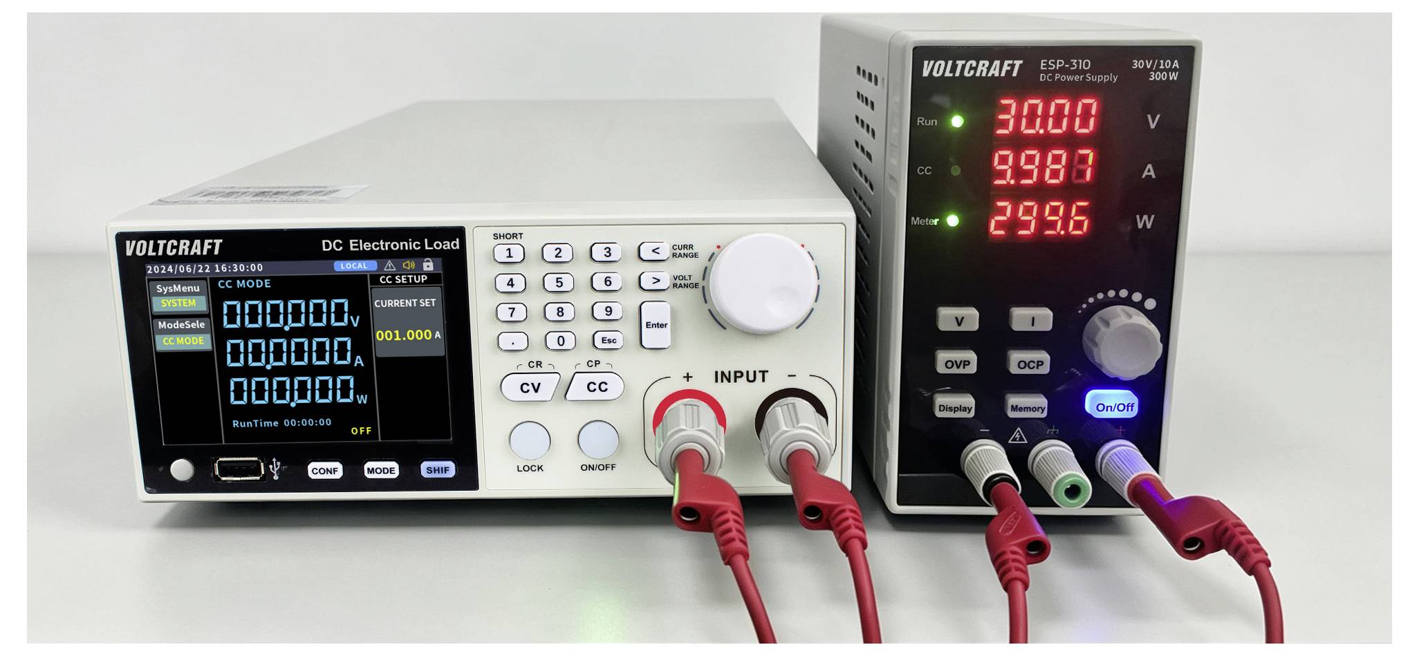 Due strumenti di prova elettronici Volcraft su un banco, con un display di carico elettronico CC sulla sinistra e una lettura di tensione/corrente/potenza sulla destra collegati da cavi rossi e neri.