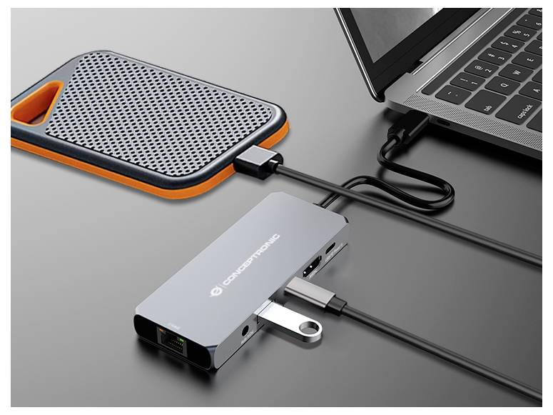 Laptop collegato a un hub/dock USB-C con unità esterna e dispositivo portatile collegati tramite cavi.