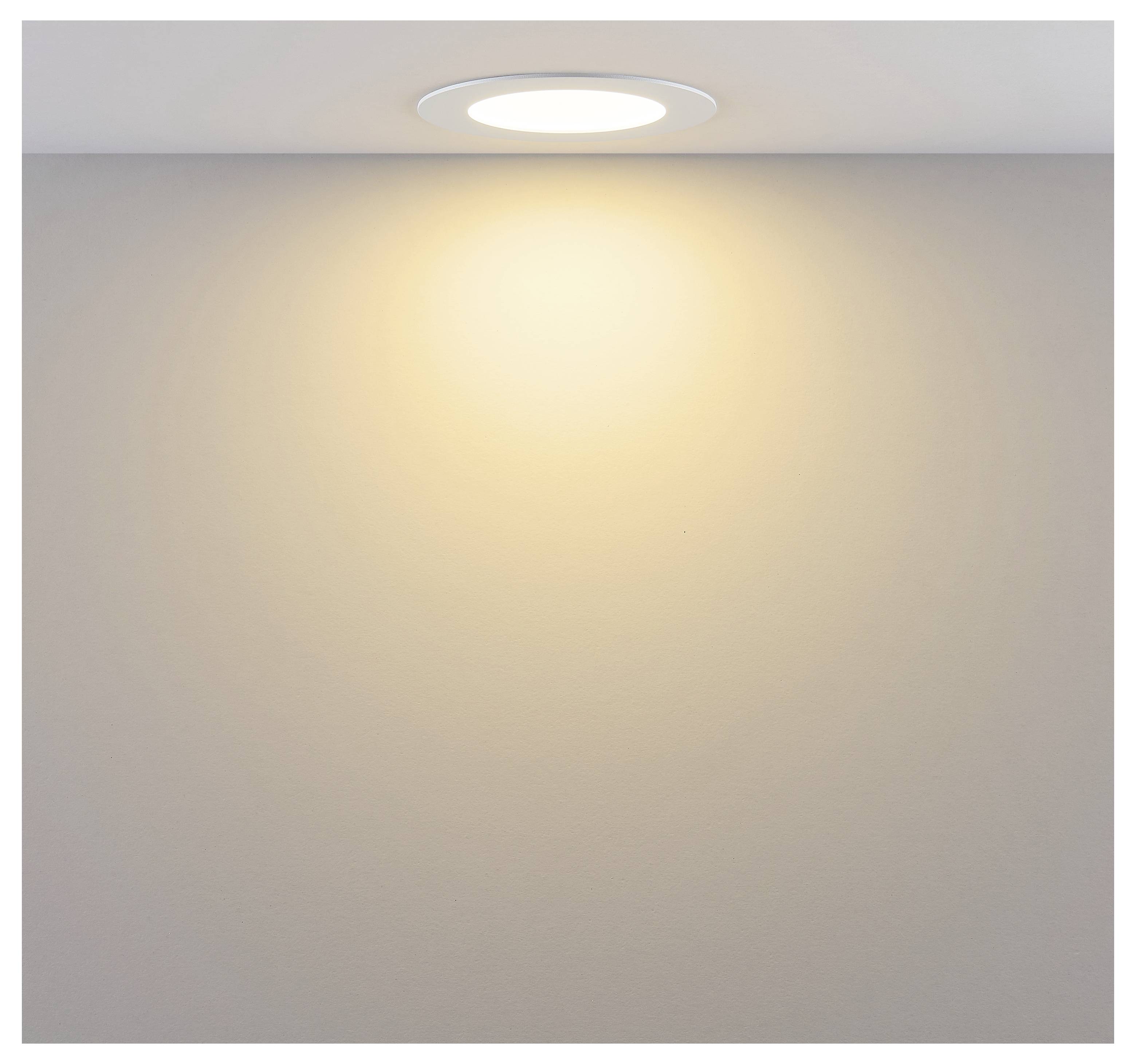 Una luce incassata nel soffitto che proietta un bagliore caldo su una parete liscia.
