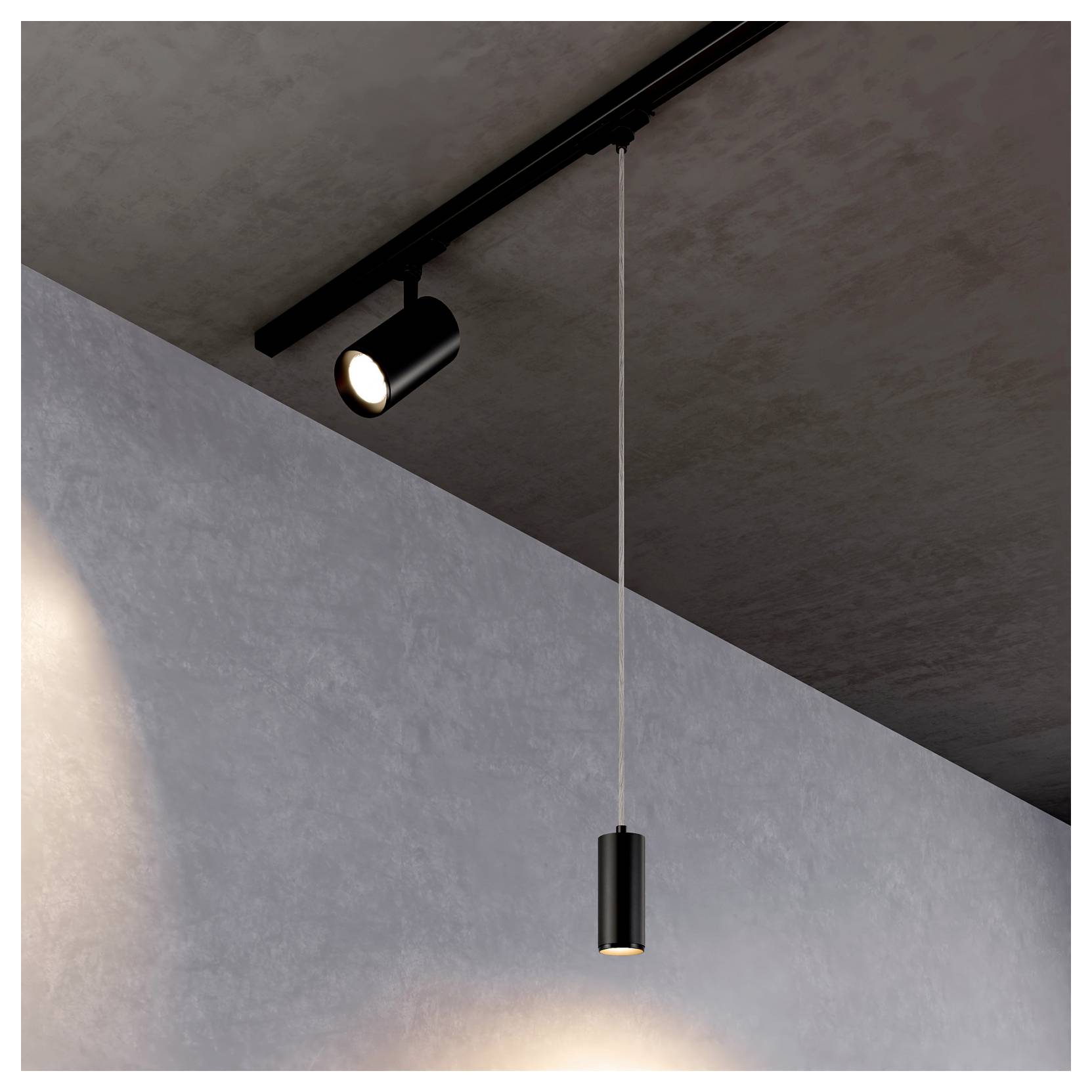 Faretti da soffitto minimalisti: un faretto nero su binario e una lampada a sospensione che illuminano una parete grigia e un soffitto scuro.