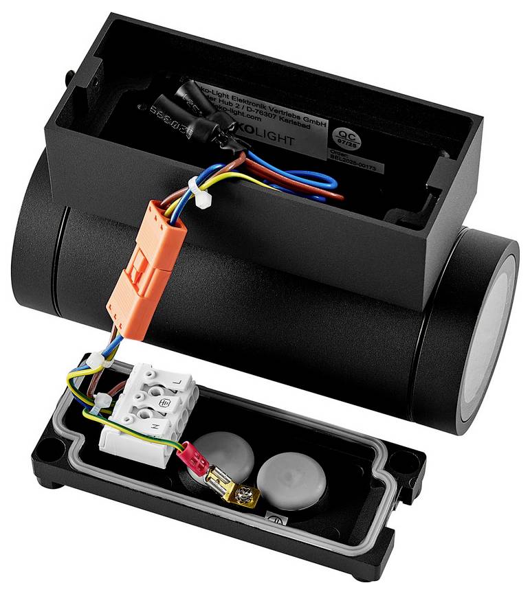 Apparecchio di illuminazione elettrico cilindrico nero aperto con coperchio rimosso, che mostra i cavi interni, il connettore arancione e la morsettiera in un vano di base separato.