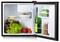 Aprire il mini frigo con cibo e bevande: lattuga, pomodori, torta, insalatiera, bottiglia di vino, cartoni di succo, e bottiglie sugli scaffali della porta.