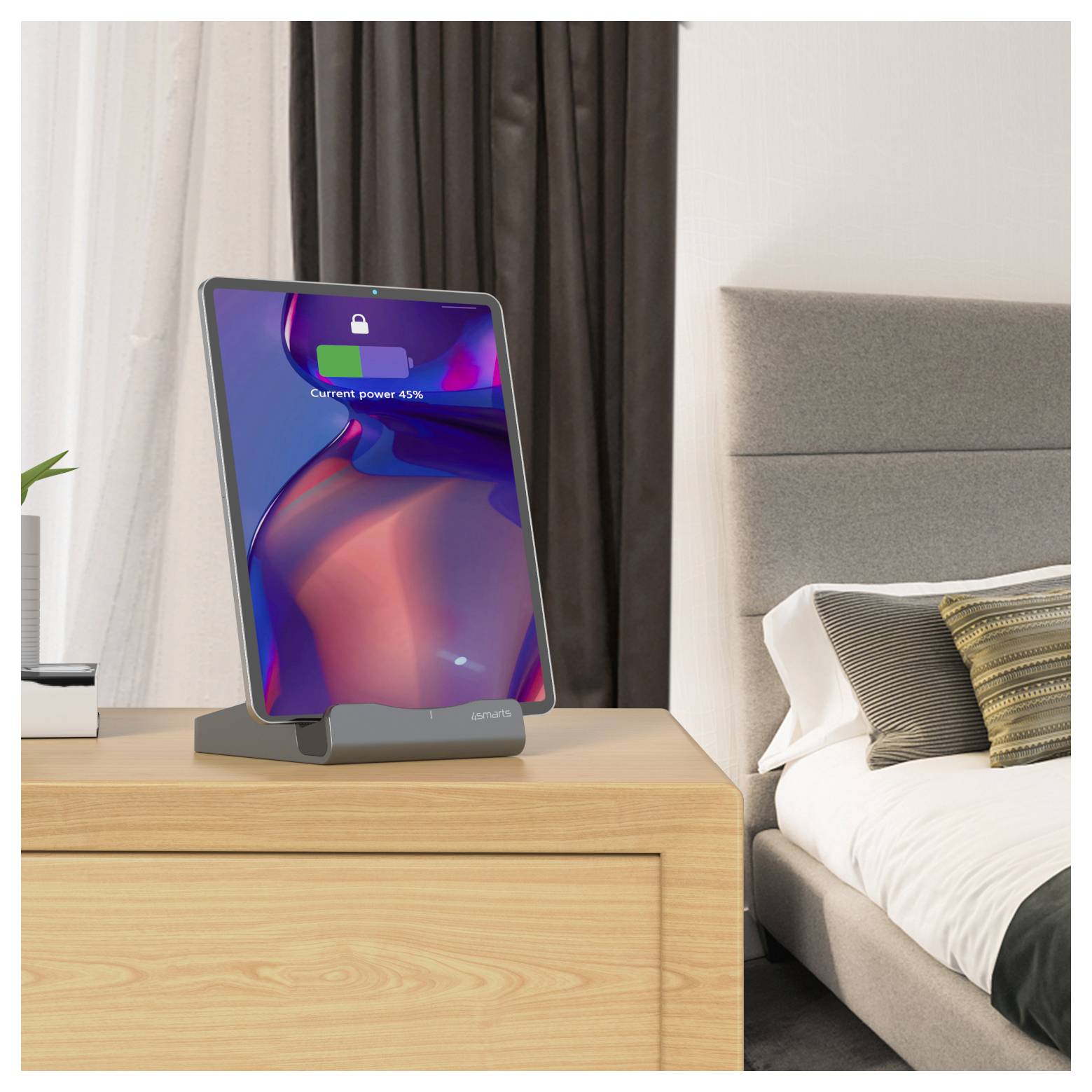 Tablet su un supporto su un comò della camera da letto, che mostra un'icona della batteria e "Potenza attuale 45%" sullo schermo.