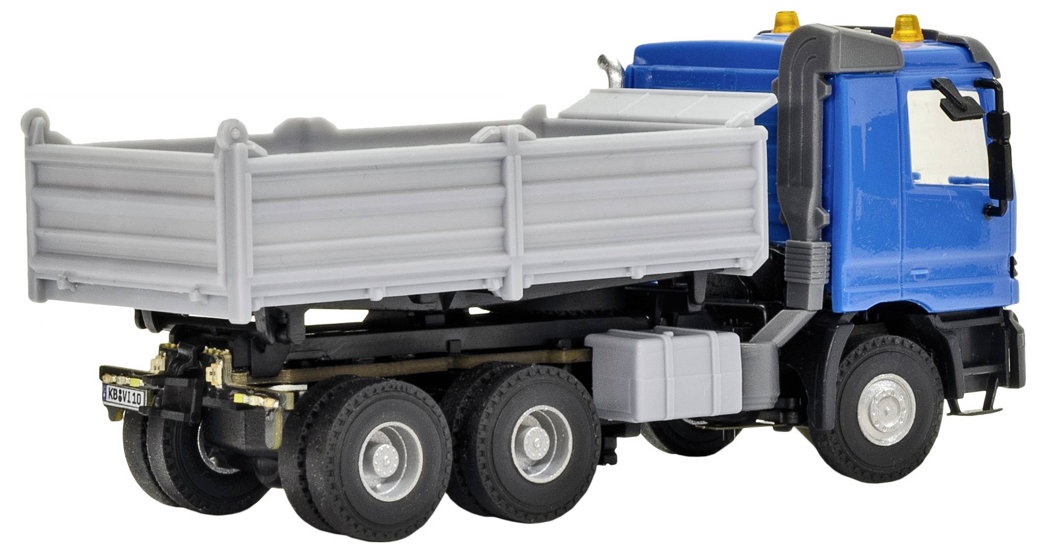 Camion ribaltabile giocattolo blu e grigio su sfondo bianco, mostrato in vista laterale.