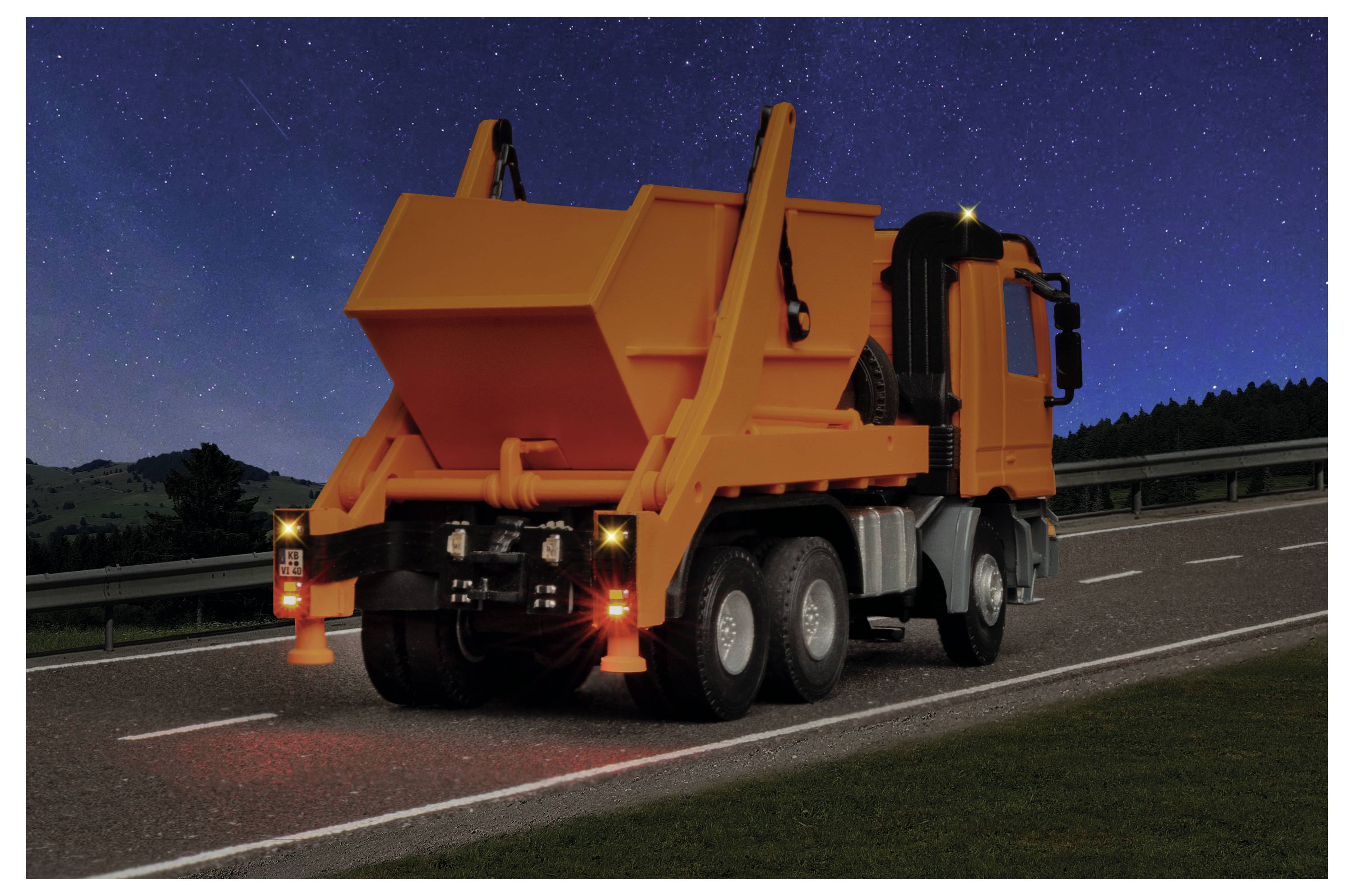 Camion ribaltabile arancione parcheggiato sulla spalla dell'autostrada di notte, con luci di avvertimento posteriori e un cono di traffico dietro di esso sotto un cielo stellato.
