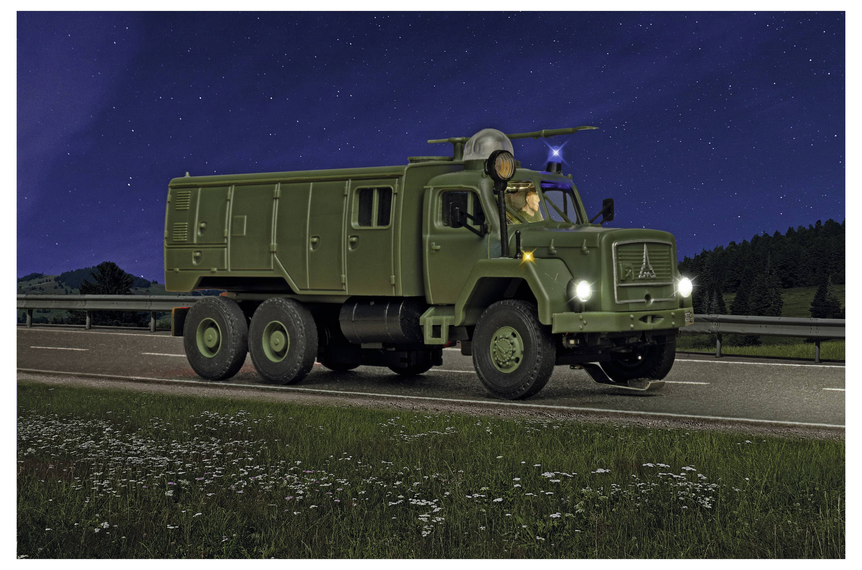 Camion militare verde che guida su un'autostrada di notte, con i fari accesi e un conducente visibile nella cabina.