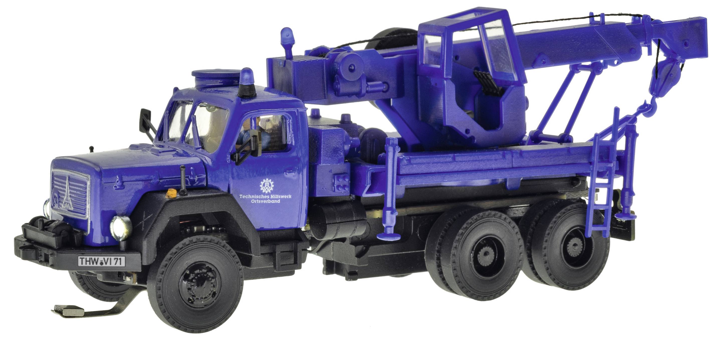 Gru blu montata su camion con braccio esteso e stabilizzatori, mostrata su sfondo bianco.