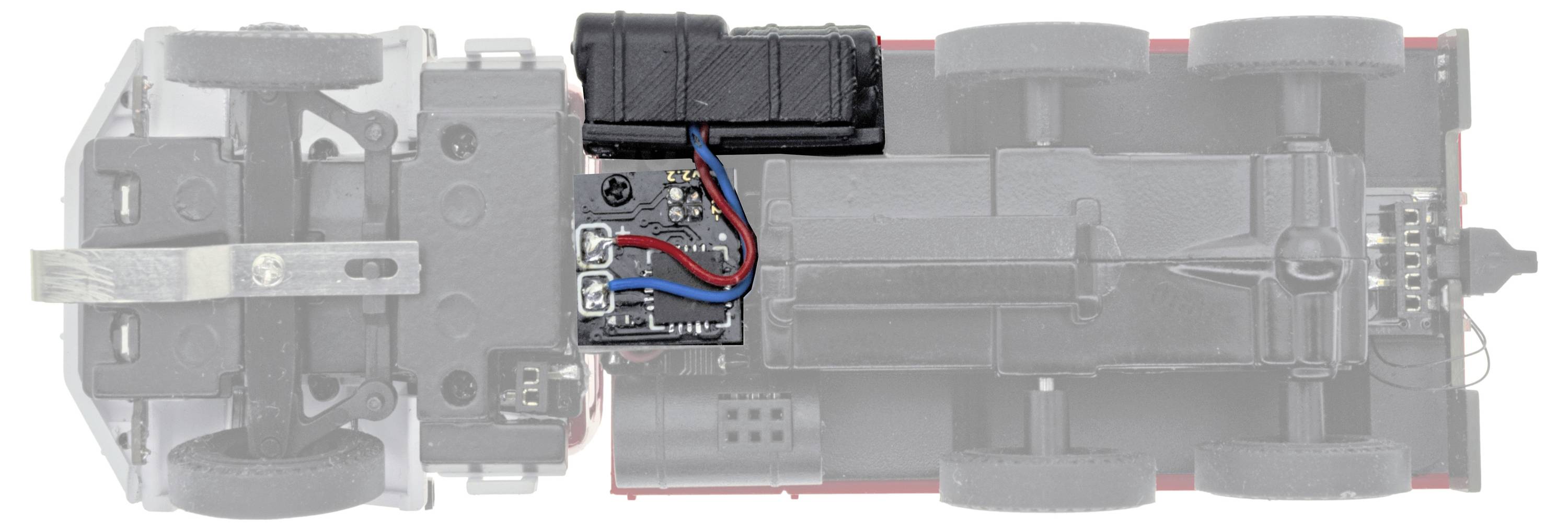 Vista dall'alto di uno chassis di un camion giocattolo con impianto elettrico a vista e vano batteria, che mostra il layout interno del motore e dei componenti elettronici.