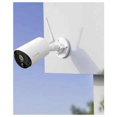 Telecamera di sicurezza wireless bianca montata su una parete dell'edificio, angolata verso l'esterno contro un cielo blu