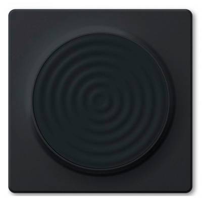 Una mano che tiene un iPhone vicino a un controllo quadrato montato a parete con un centro circolare, suggerendo un'interazione con un interruttore intelligente o un dispositivo in stile NFC.