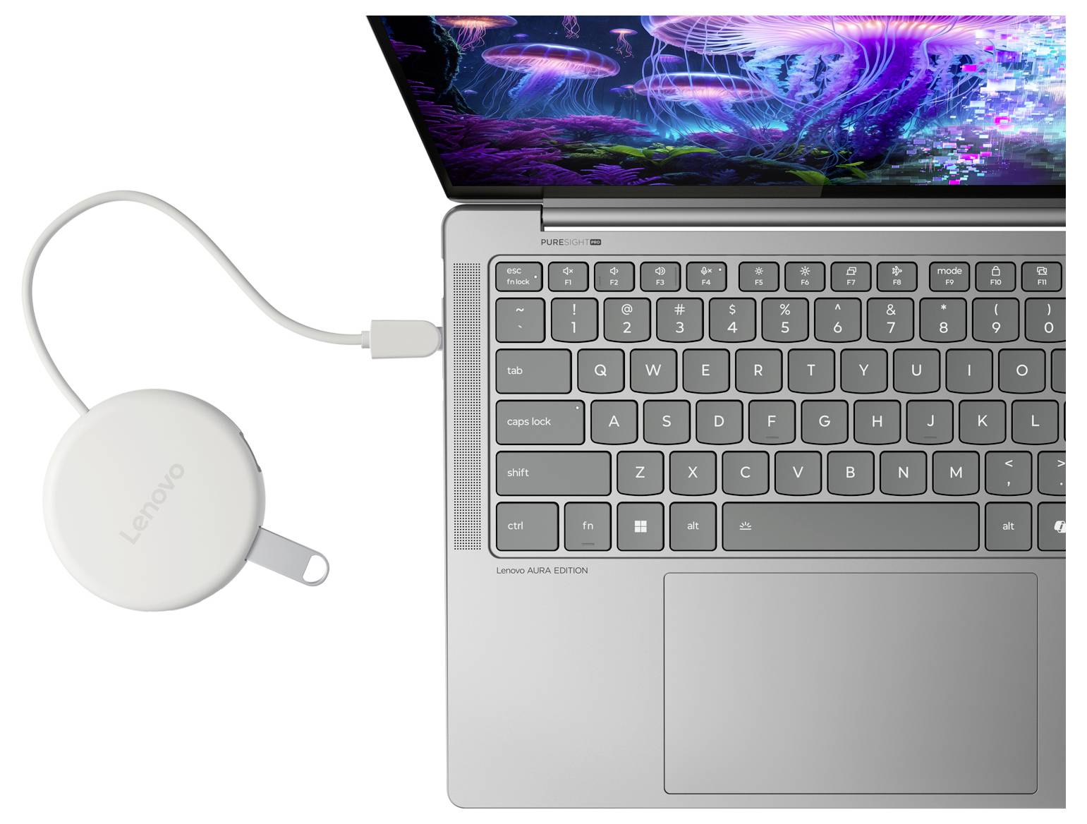 Un laptop Lenovo bianco con un cavo USB-C collegato a un piccolo adattatore rotondo o dock posizionato accanto ad esso.