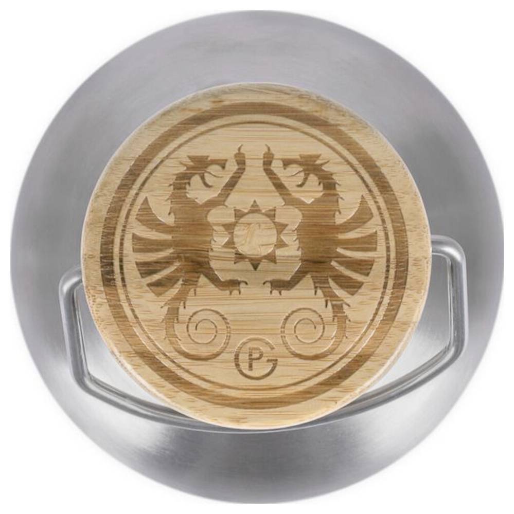 Coperchio in bambù rotondo con stemma dell'aquila a due teste inciso, poggiato in un supporto in acciaio inossidabile.