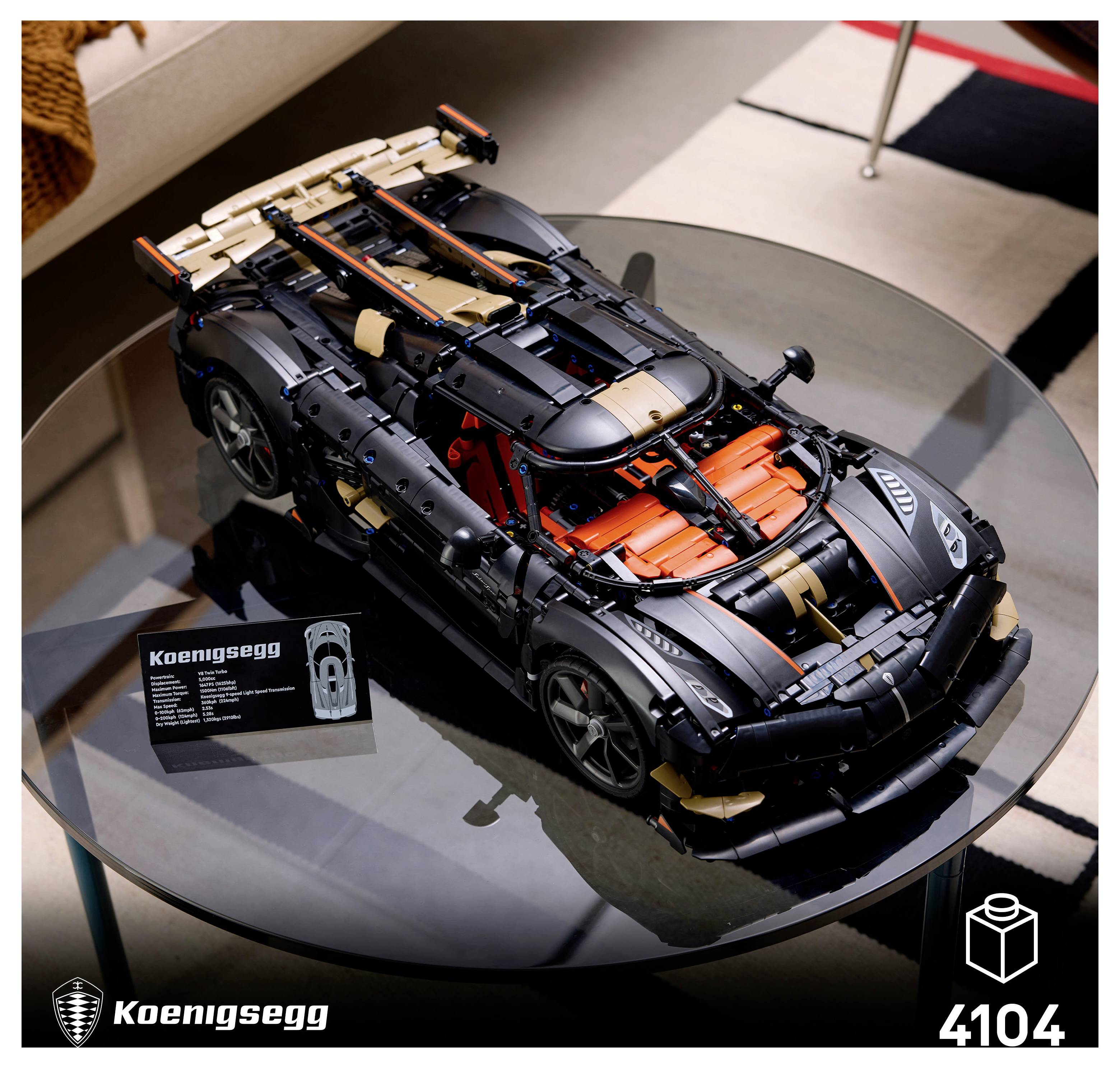 Modello di supercar LEGO Koenigsegg su un tavolo espositivo, che mostra i dettagli meccanici esposti e le parti del motore arancioni, etichettato 4104.