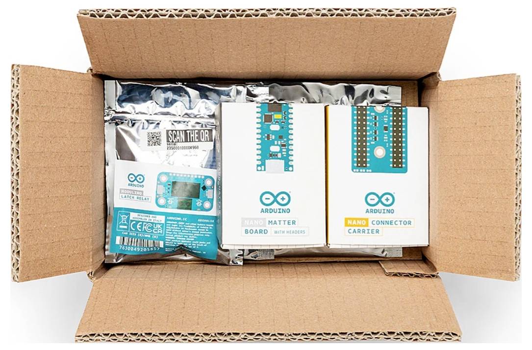 Scatola di cartone aperta contenente kit di elettronica Arduino e schede in confezioni etichettate, inclusa la "Scheda Arduino Matter" e il "Carrier Connettore Arduino Nano".