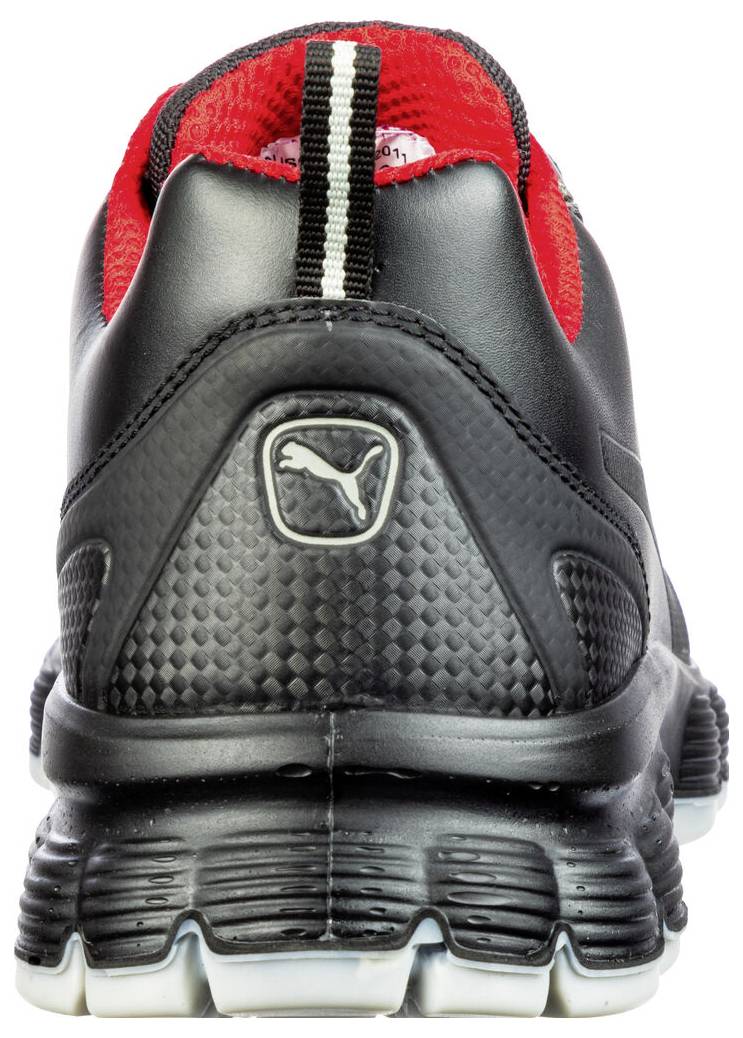 Vista posteriore di una scarpa atletica Puma nera e rossa con una suola spessa e strutturata su uno sfondo bianco.