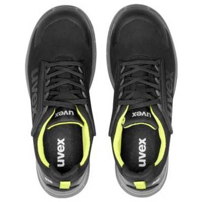 Paio di scarpe atletiche Uvex nere con accenti giallo neon mostrate da sopra su uno sfondo bianco.