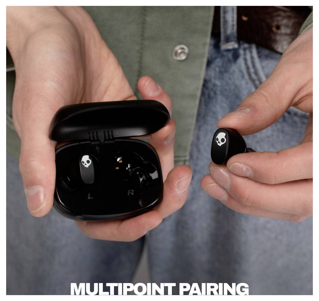 Le mani tengono un astuccio aperto per gli auricolari wireless e un auricolare corrispondente, con il testo in basso che recita "MULTIPOINT PAIRING".