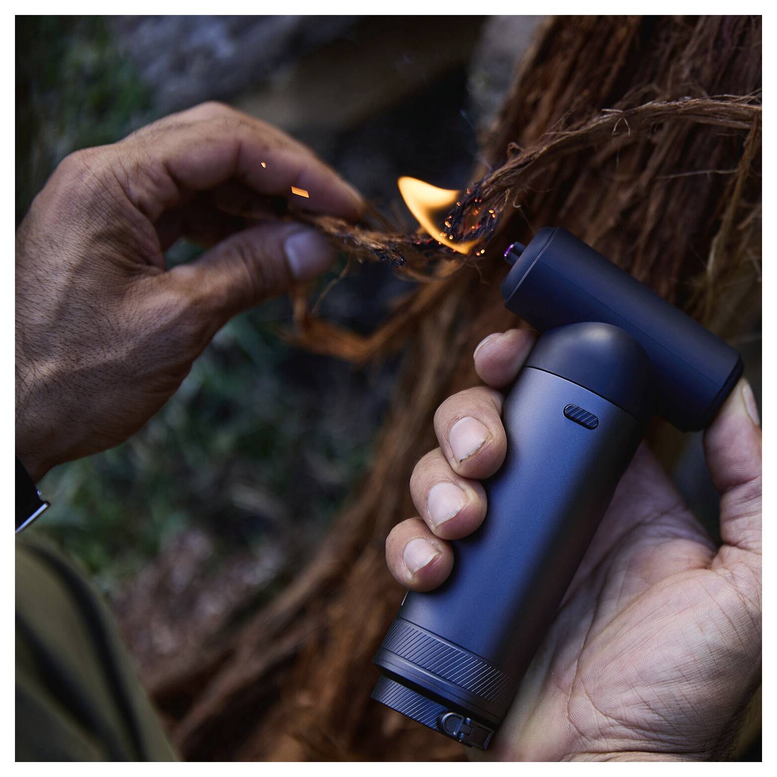 Una persona utilizza uno strumento per capelli elettrico portatile per bruciare una piccola sezione di capelli mentre tiene la ciocca con l'altra mano.