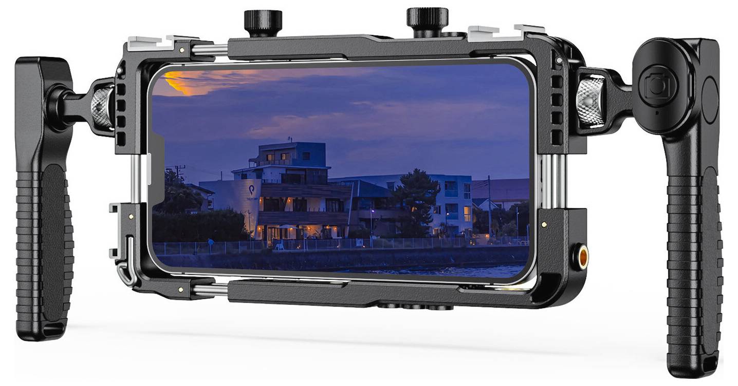 Smartphone in a dual-handle stabilizer/cage, showing a dusk city-building scene on the phone screen.<br><br>Smartphone in una gabbia/stabilizzatore a doppio manico, che mostra una scena di costruzione di una città al tramonto sullo schermo del telefono.
