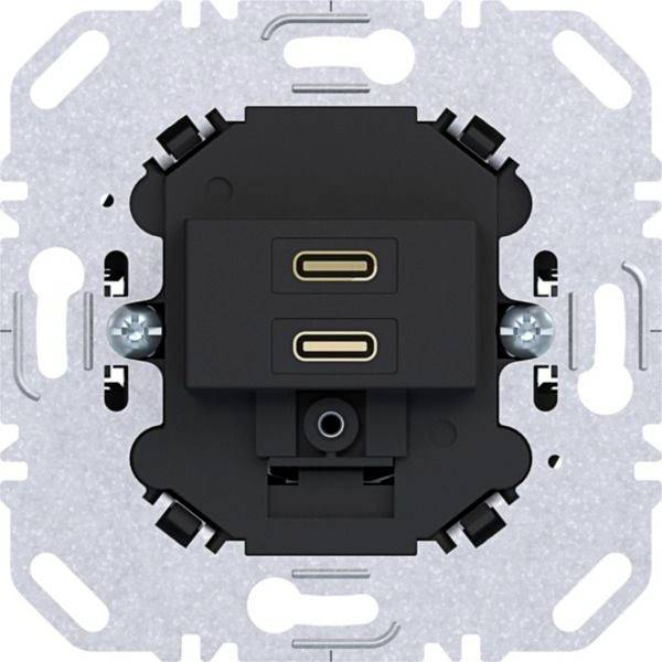 Vista posteriore di un interruttore a parete nero o meccanismo di presa montato su una staffa elettrica metallica, che mostra doppi porta USB-C e morsetti di cablaggio.