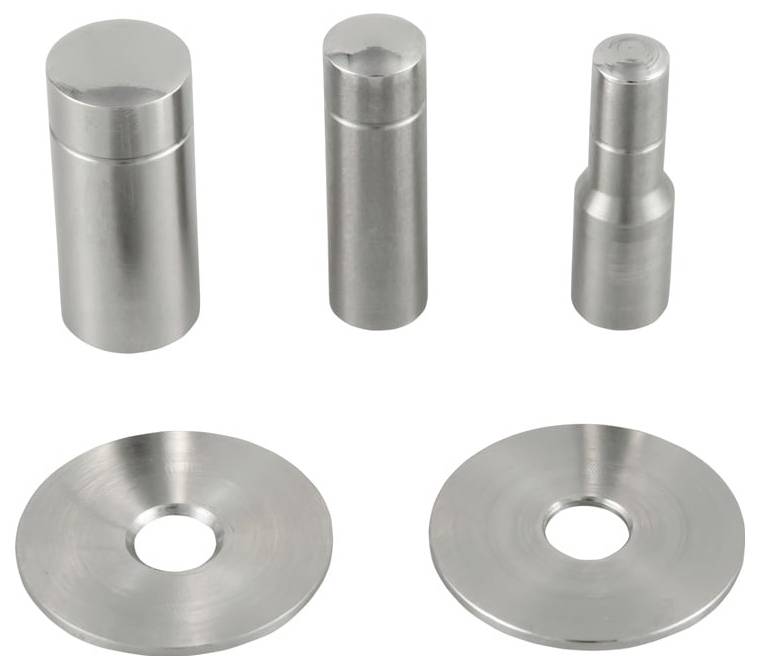 Cinque parti metalliche in argento lavorate a macchina esposte su uno sfondo bianco: tre pezzi cilindrici in alto e due dischi circolari piatti con fori centrali sottostanti.