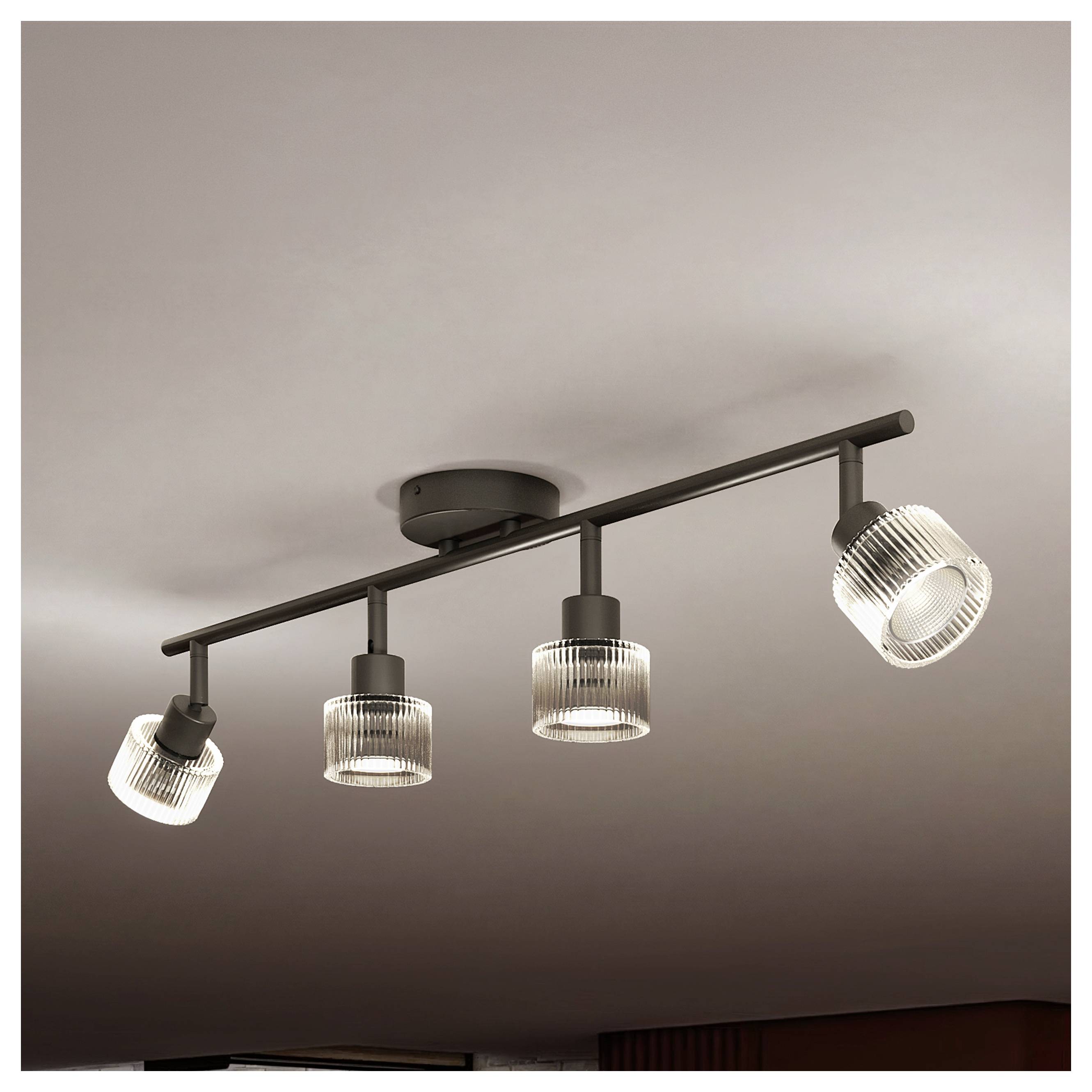 Apparecchio di illuminazione a soffitto su binario nero con quattro paralumi in vetro rigato orientabili