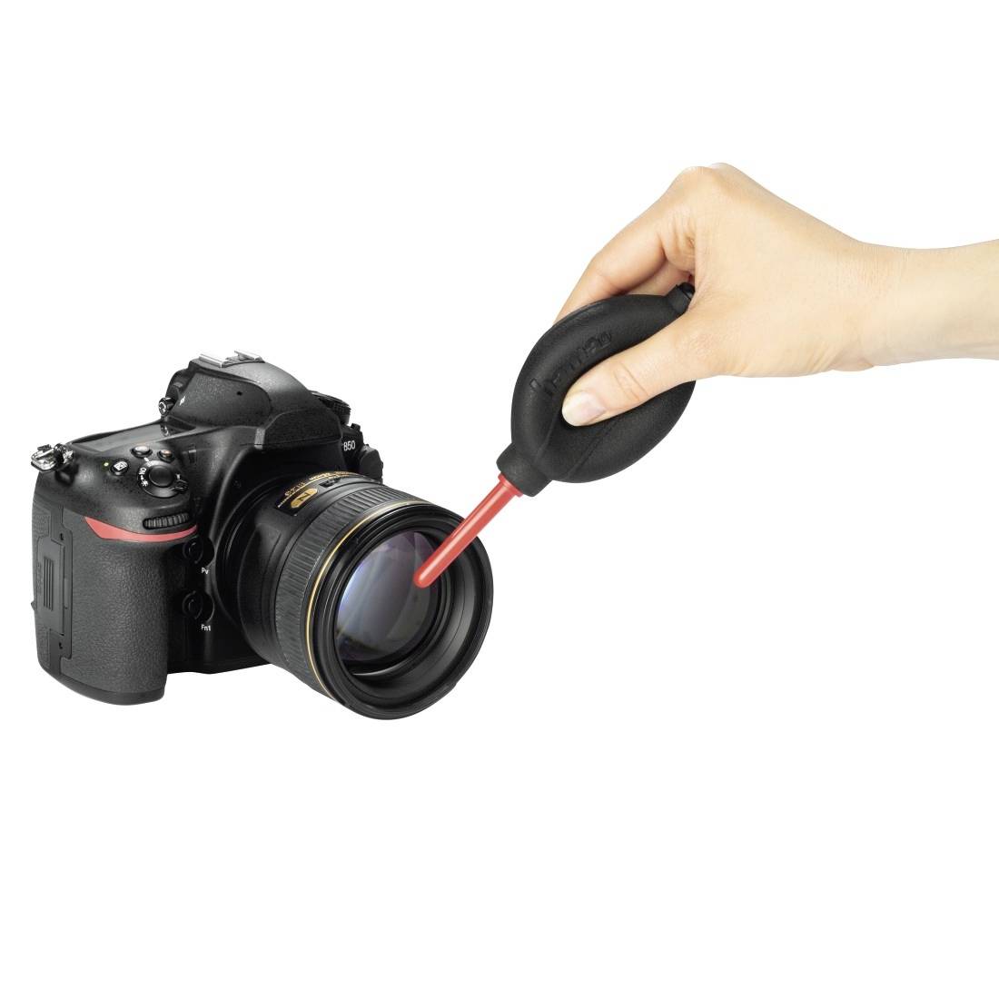 Pulizia manuale della lente della fotocamera con soffietto ad aria su una fotocamera DSLR.