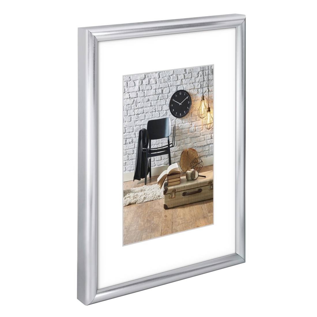 Cornice da parete in argento che espone una scena di una stanza in allestimento con sedia, orologio, lampada a sospensione e tavolo in stile valigia