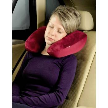 Donna che dorme indossando un cuscino da viaggio a forma di U, seduta in posizione verticale sul sedile dell'auto.