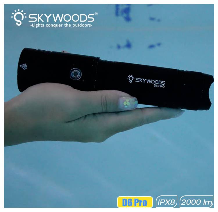 Mano che tiene una torcia Skywoods D6 Pro sott'acqua; le etichette sull'immagine recitano 'D6 Pro', 'IPX8' e '2000 lm'.