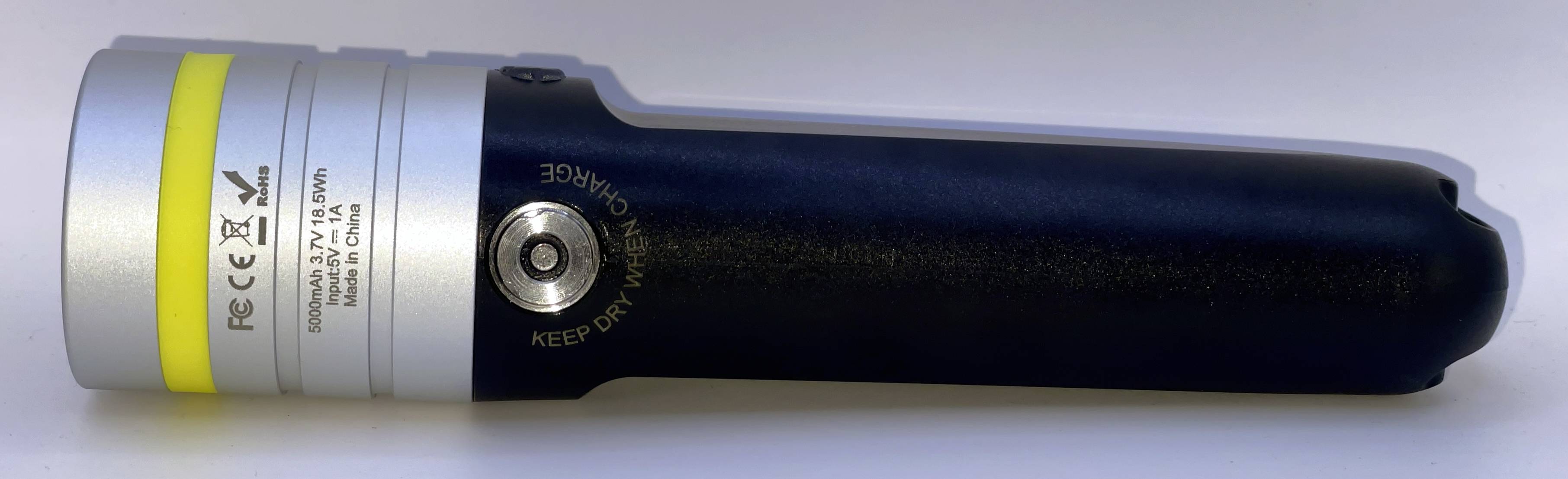 Dispositivo portatile alimentato a batteria posato su un lato, con involucro color argento e blu navy, una banda gialla e un pulsante rotondo "KEEP DRY" vicino al centro.