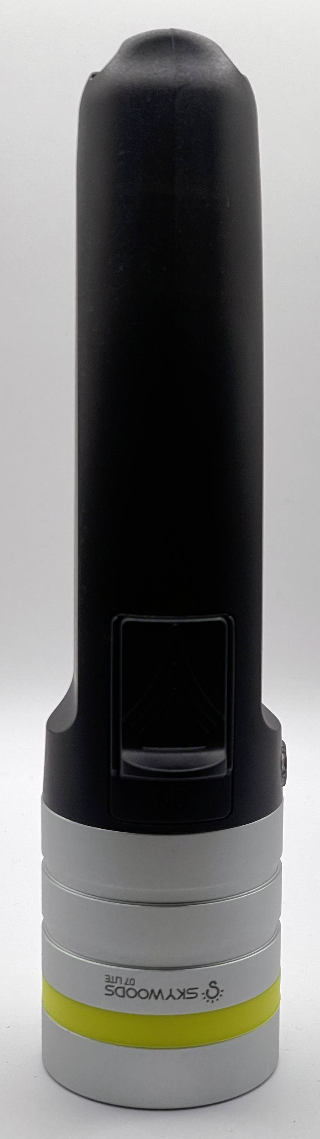 Dispositivo cilindrico nero portatile con un piccolo display quadrato sul frontale, montato su una base grigia con una fascia gialla.