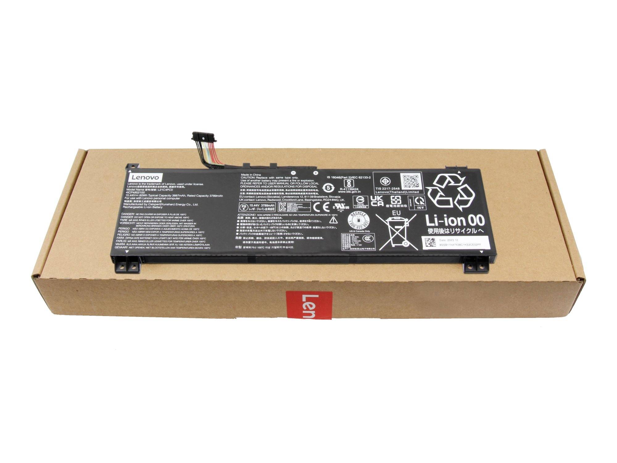 Pacco batteria per laptop Lenovo in una scatola di spedizione in cartone, vista dall'alto con etichette e connettore visibili.