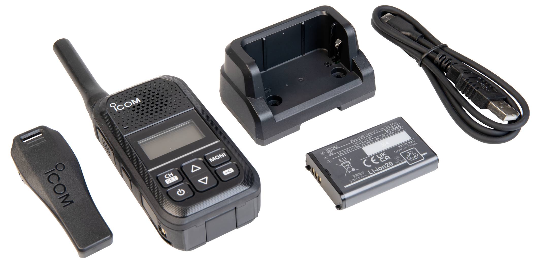 Kit ricetrasmittente ICOM portatile wireless con supporto di ricarica, pacco batteria, clip per cintura e cavo di alimentazione su sfondo bianco