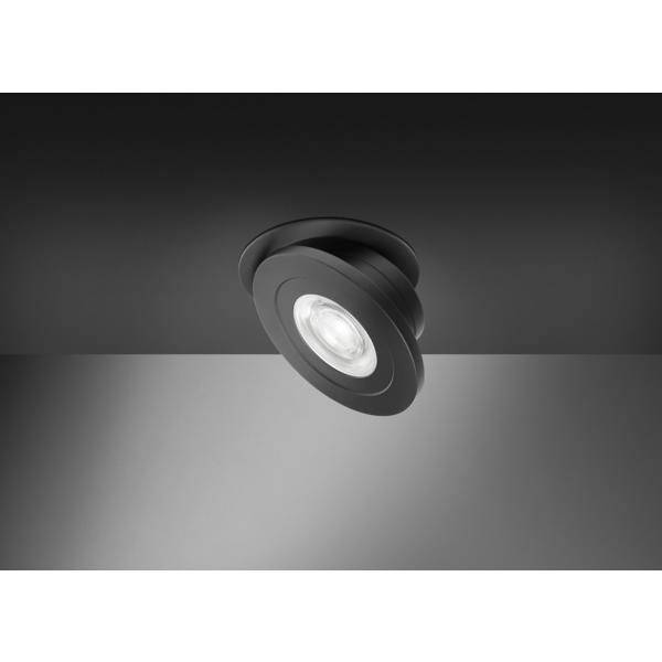 Faretti da incasso nel soffitto di colore nero rivolti verso il basso che illuminano una parete grigia, con una ghiera rotonda moderna e regolabile.