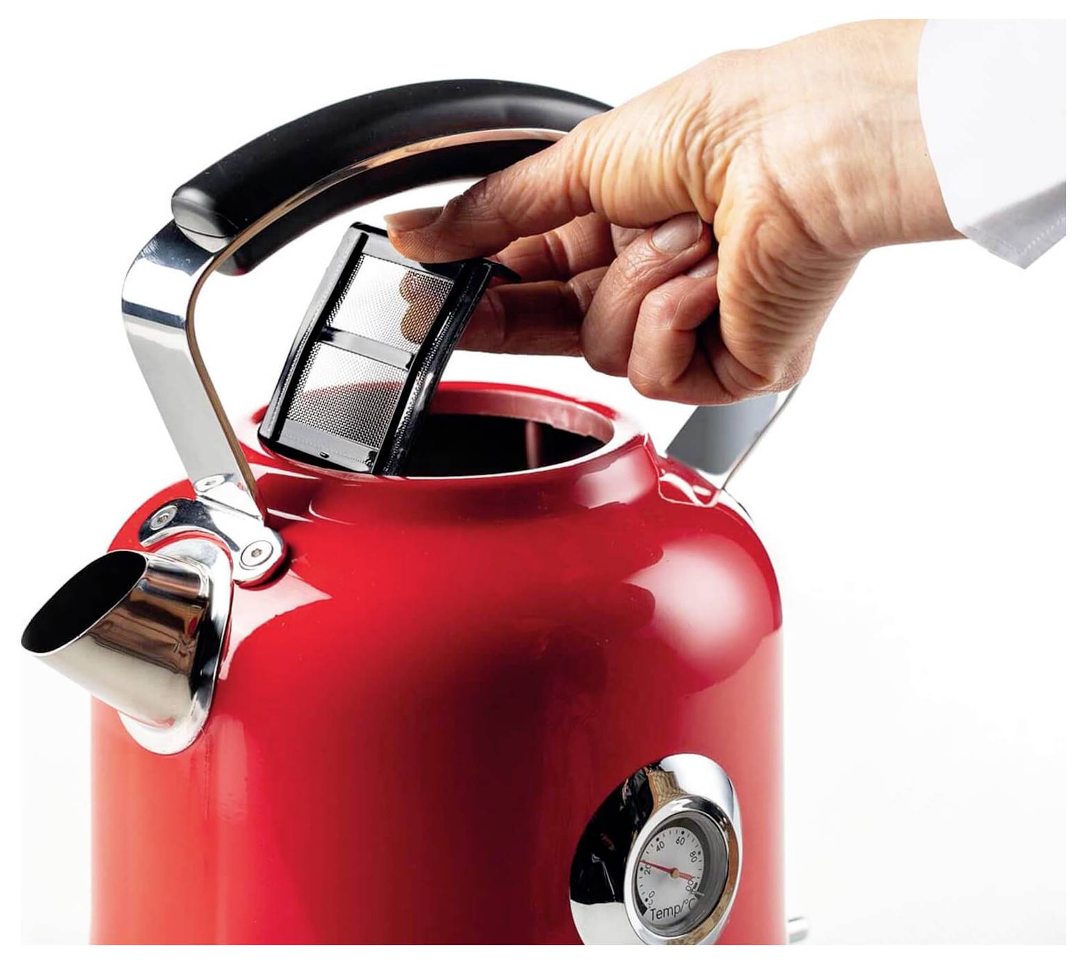 Una mano che ripone un infusore per il tè in un bollitore elettrico rosso con un indicatore di temperatura.
