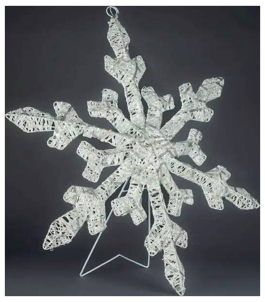 Ornamento fiocco di neve bianco realizzato in materiale intrecciato o simile a pizzo, esposto su un supporto su sfondo scuro.