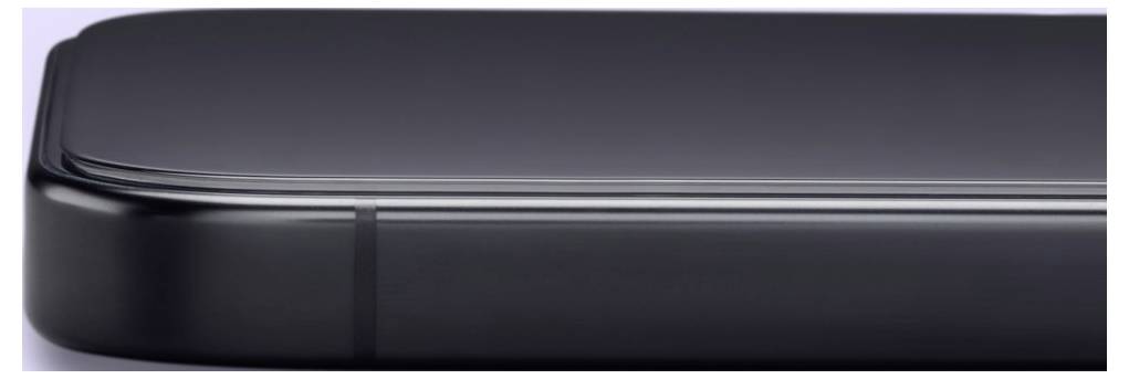 Primo piano del bordo elegante di uno smartphone o tablet nero, che mostra lo schermo lucido e la scocca metallica arrotondata.