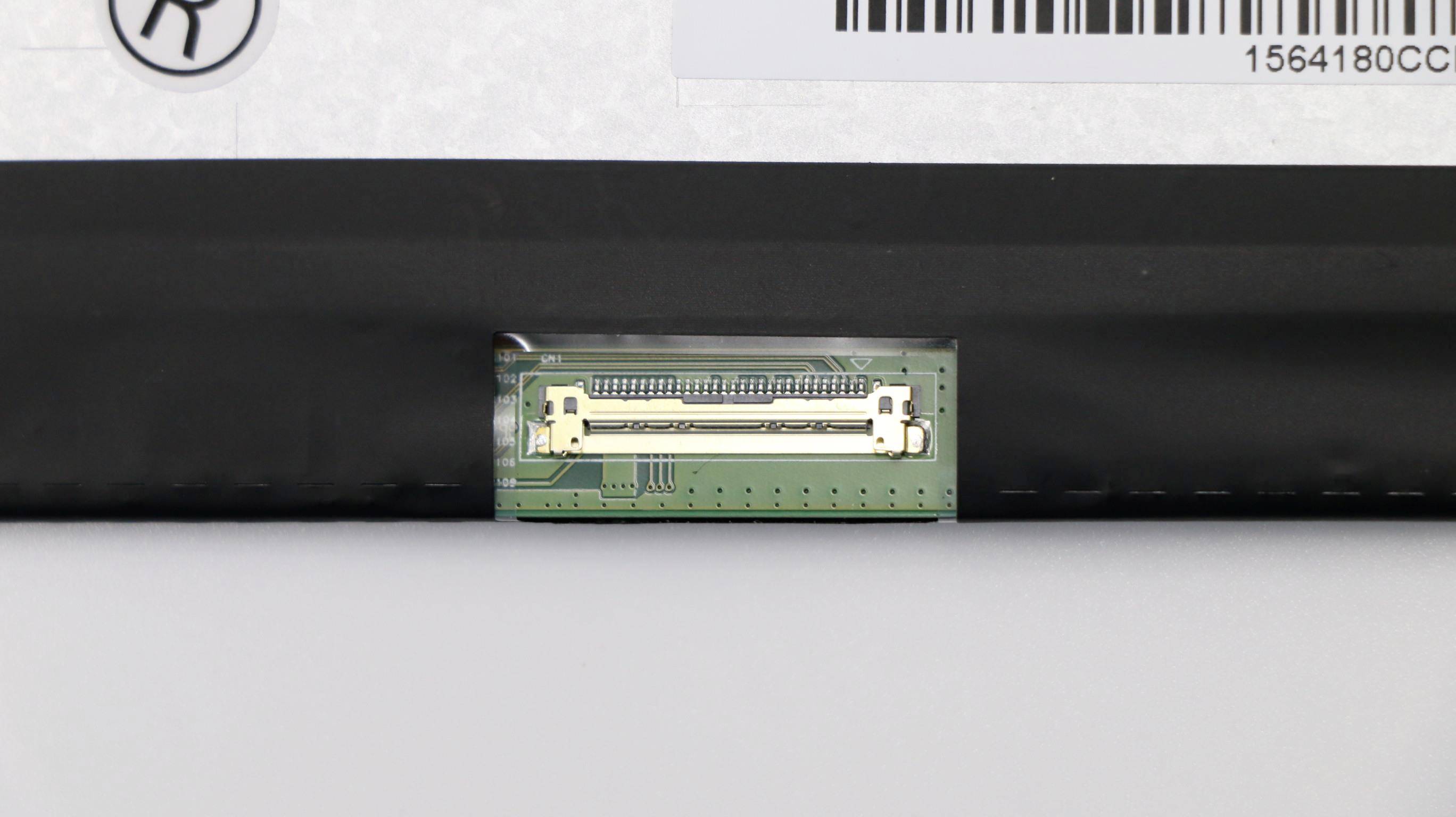 Primo piano di una scheda a circuiti verdi con un connettore elettronico bianco montato in uno slot di dispositivo nero, con un'etichetta con codice a barre sopra.