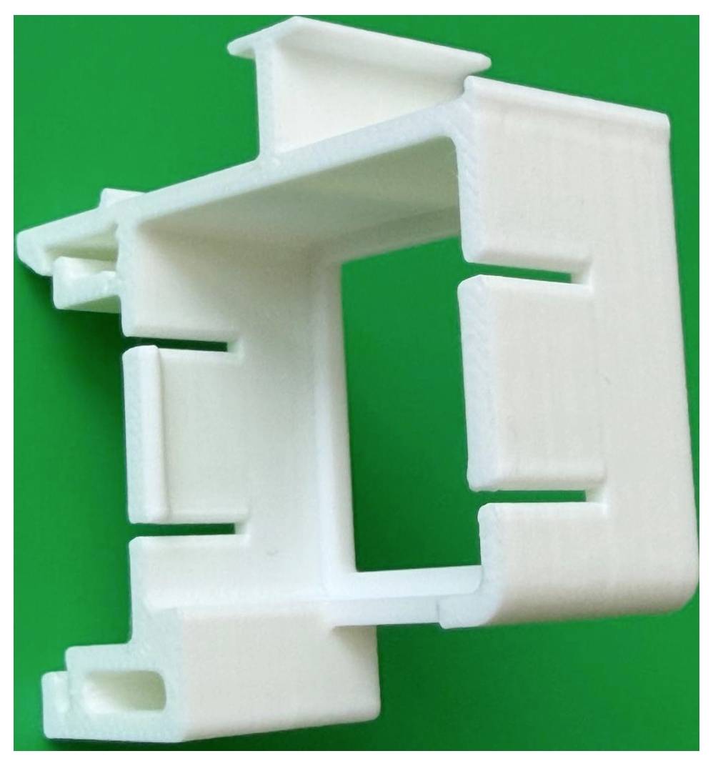 Clip o staffa in plastica bianca con centro aperto, mostrato su uno sfondo verde brillante.