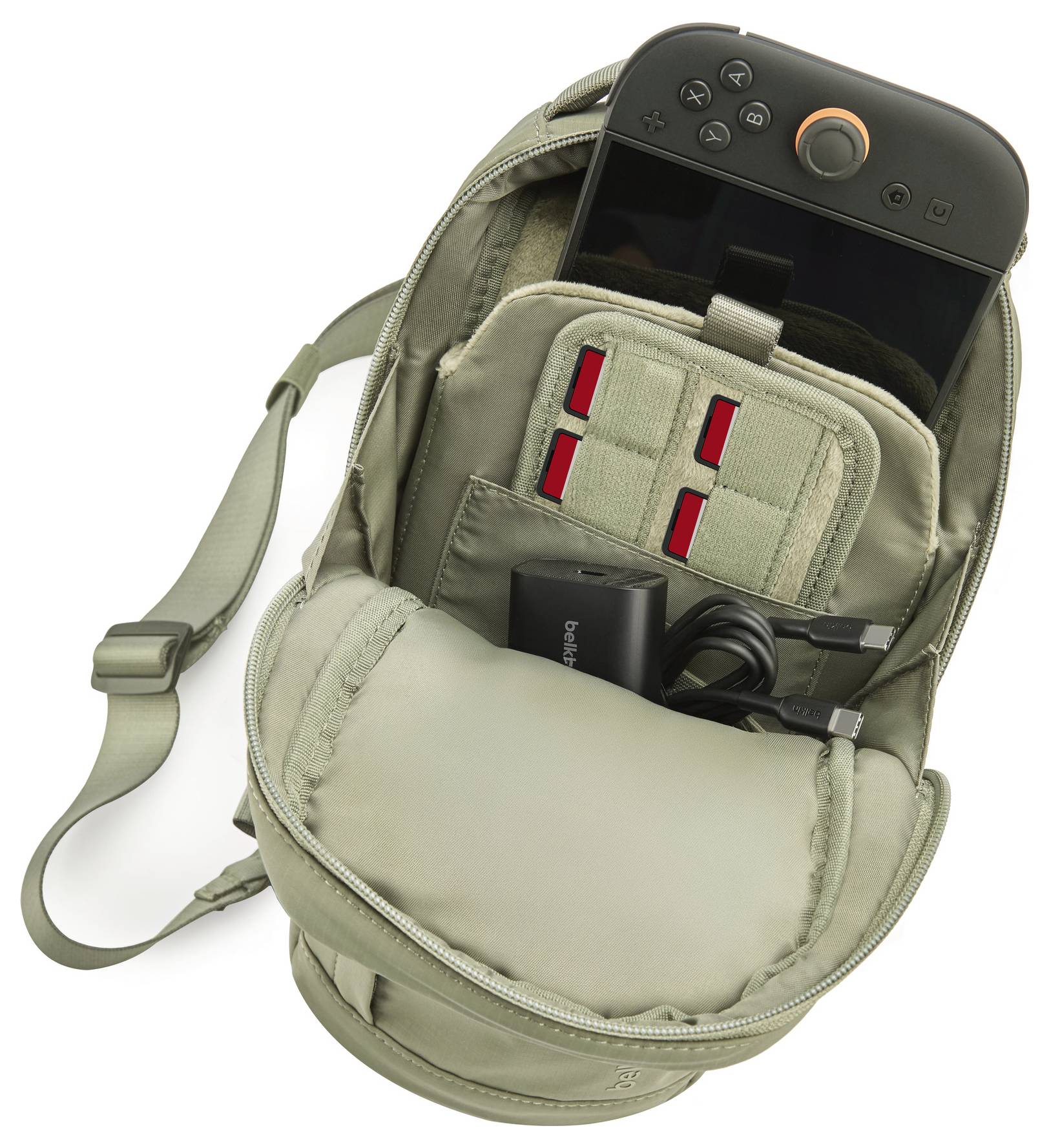 Zaino aperto con una console portatile per il gioco, caricabatterie e cavi all'interno, che mostra scomparti organizzati e una tracolla.