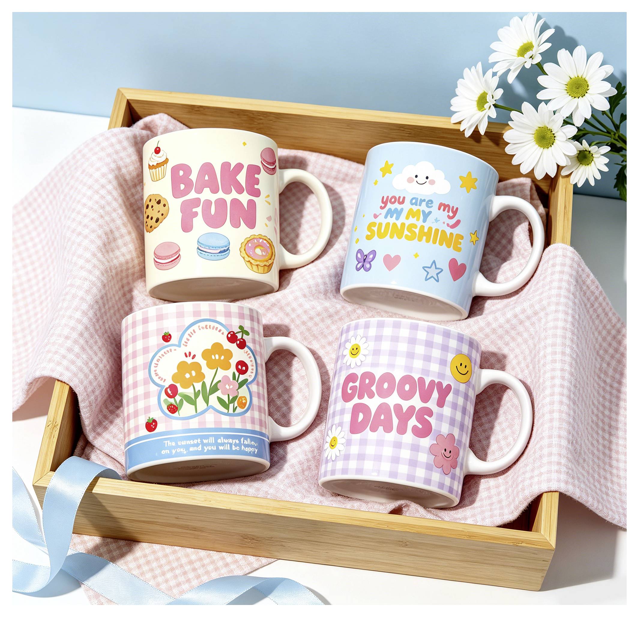 Quattro tazze decorate in un vassoio di legno su un panno rosa: 'BAKE FUN', 'you are my sunshine', design floreale, e 'GROOVY DAYS'.