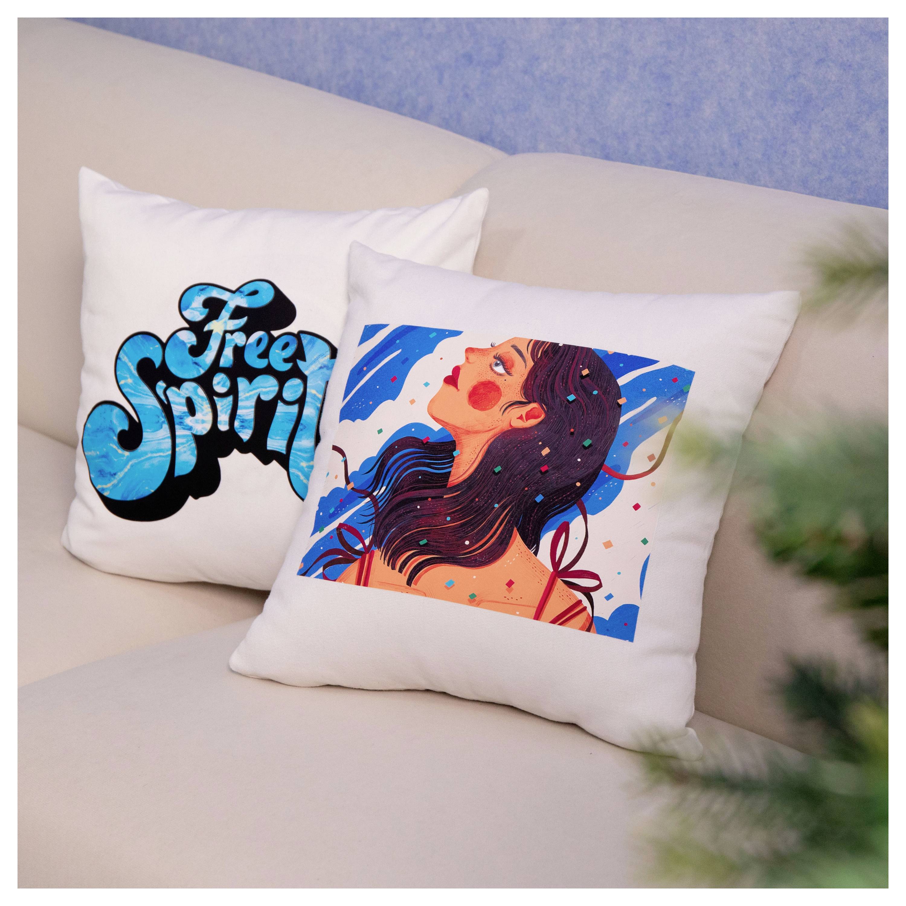 Due cuscini decorativi gettati su un divano beige, uno con il testo "Free Spirit" e uno con un'illustrazione colorata di una donna.
