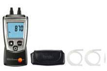 Strumento di misurazione digitale con display '870'; due connessioni in alto. Accanto una borsa nera e due supporti trasparenti.