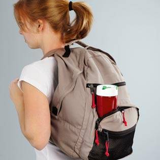 Una persona con uno zaino beige porta una bottiglia d'acqua rossa nel tasca laterale.